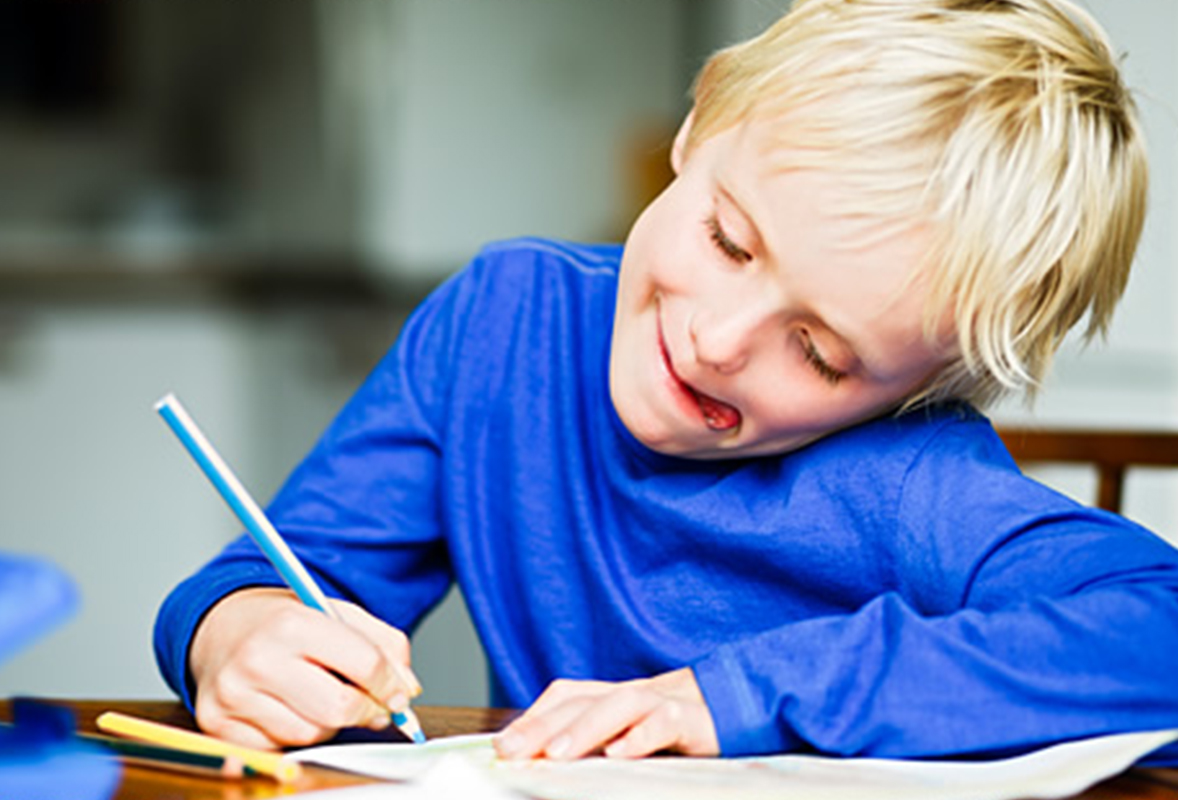 A boy making a drawing on the table